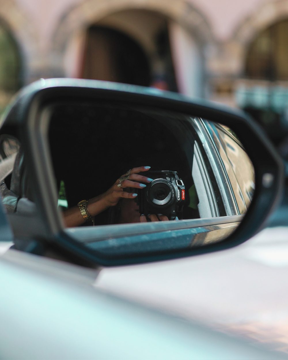 Coralie photographing herself in a car mirror